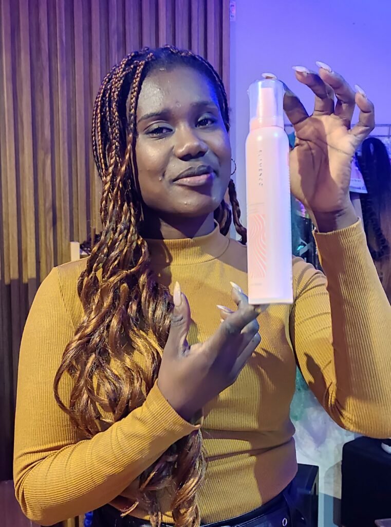 Betty Cyprien, estilista profesional, con espuma para peinar en la mano.